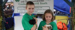 Two Children Holding Guinea Pigs | Scholarships and Awards