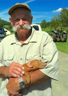 Man Holding a Baby Pig | Year Round Workshops